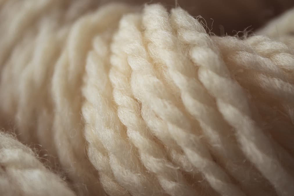Blødt, cremehvidt garn i nærbillede med fine, bløde fibre
